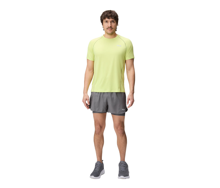 Homme portant un t-shirt technique FILA vert citron, un short gris et des baskets grises.