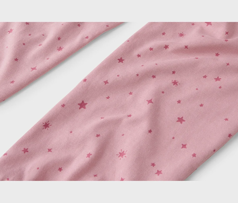Tissu rose avec des motifs d'étoiles rose foncé, incluant des formes pleines, des contours et des étoiles éclatantes.