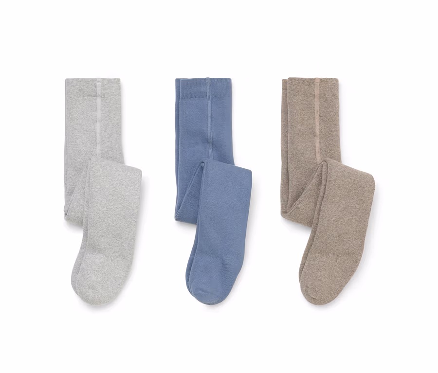 Trois paires de collants pliés posés à plat sur un fond blanc : gris clair, bleu et beige.
