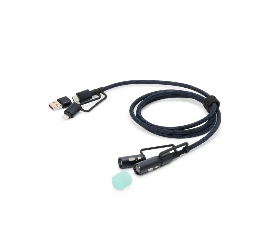 Un câble de charge bleu avec des connecteurs USB, USB-C et Lightning, ainsi que deux petites lumières LED et un embout en silicone, est posé sur un fond blanc.