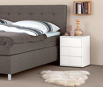 Lit boxspring avec table de chevet boxspring et décorations.