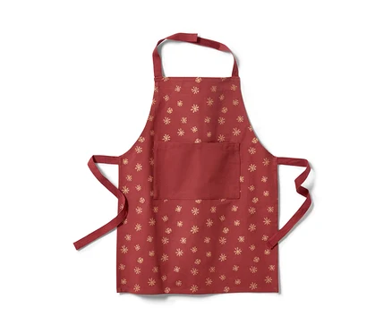Un tablier rouge pour enfant avec un motif de flocons de neige dorés.
