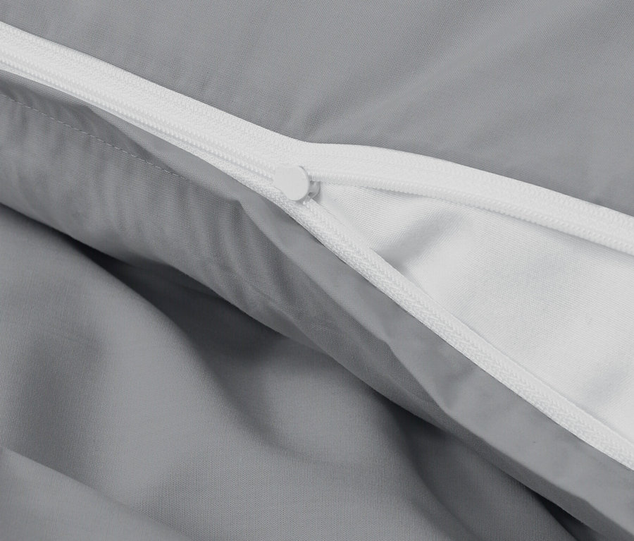 Gros plan d'une parure de lit en percale grise avec fermeture éclair.