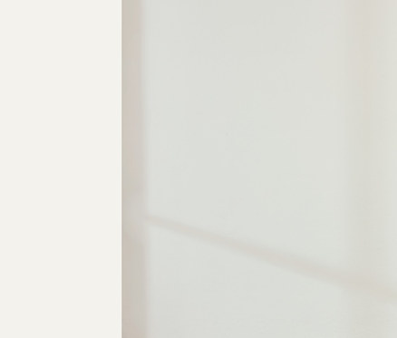 Une femme se tient dans une pièce et porte un t-shirt et un pantalon de jogging beiges clairs. Elle porte un Heavy Weight Shirt NAH/STUDIO et un pantalon de jogging NAH/STUDIO en coton durable.