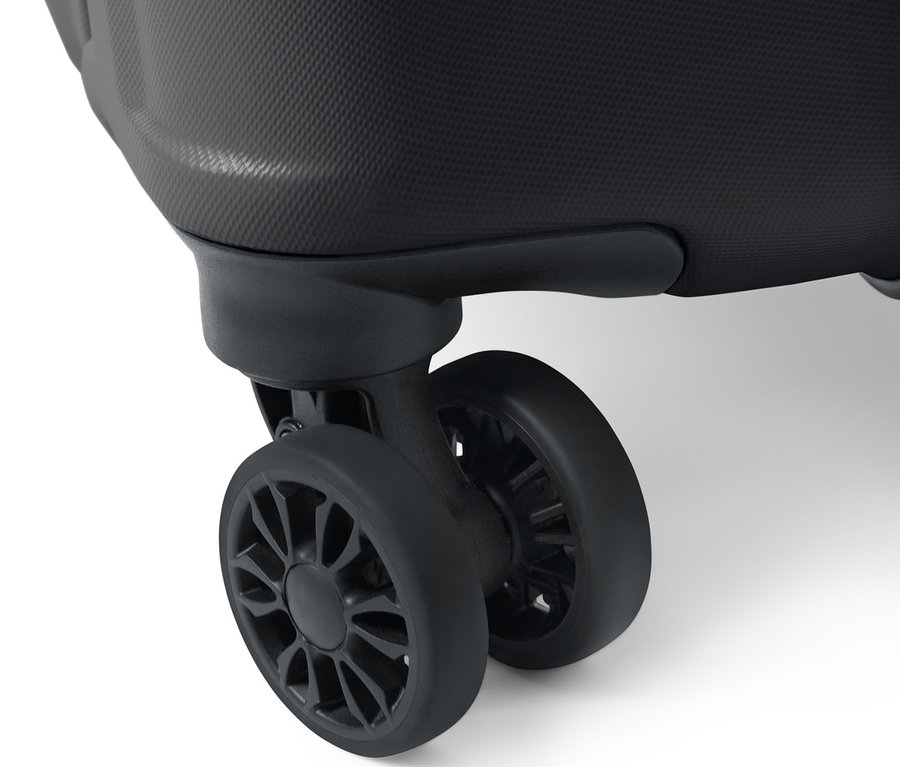 Gros plan d'une grande valise rigide montrant la surface texturée et deux roues noires.