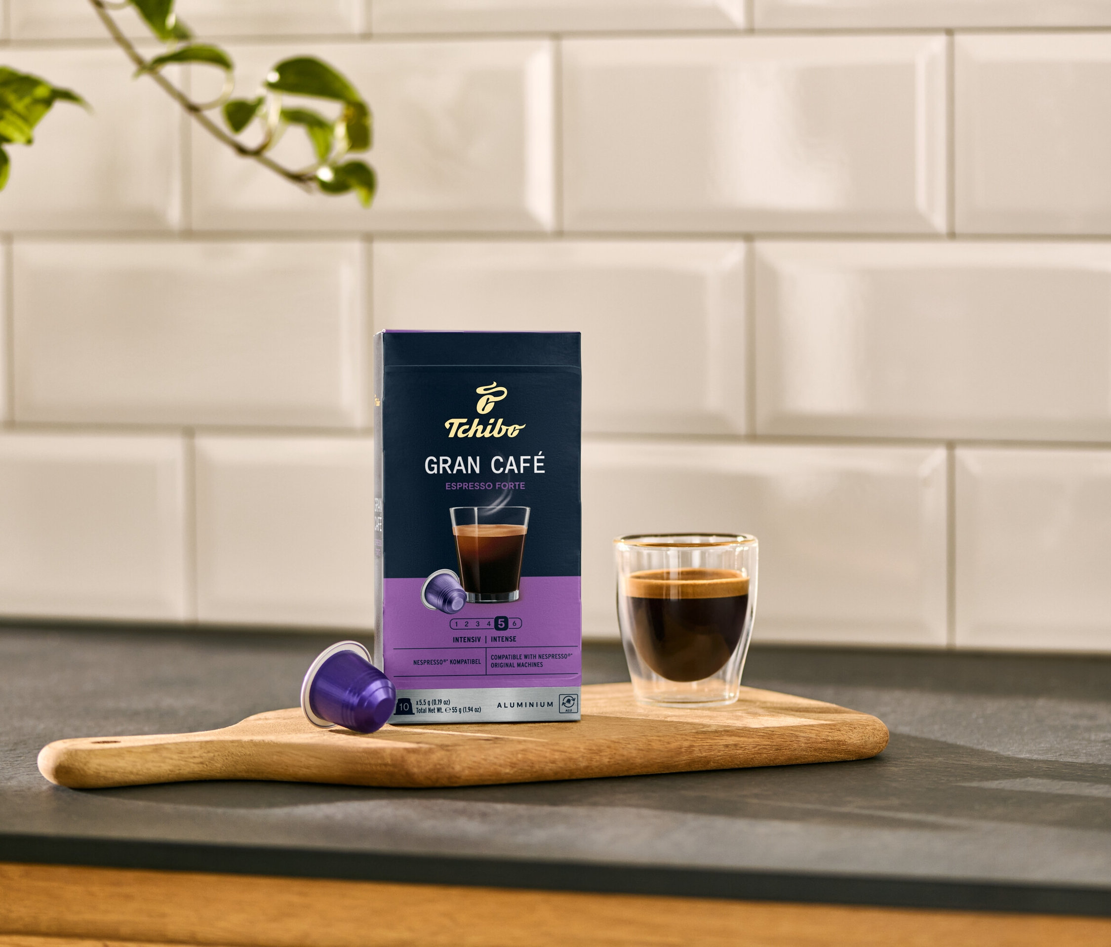 Un paquet de capsules Gran Café Espresso Forte à côté d'une tasse à expresso sur une planche.
