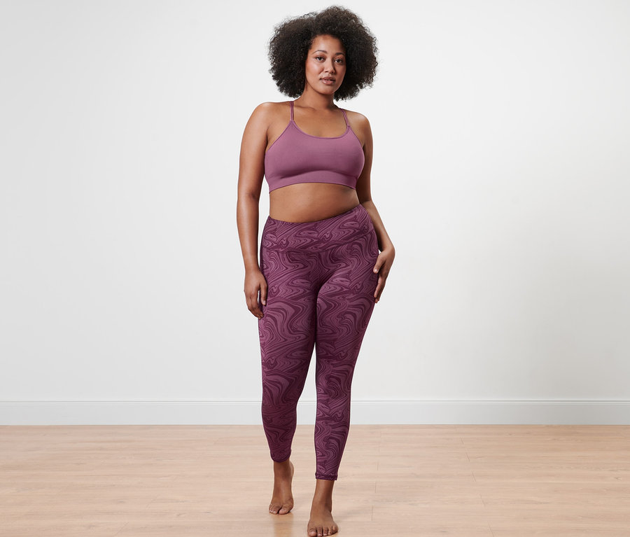 Une femme pose en brassière de sport sans coutures et legging de sport 7/8.