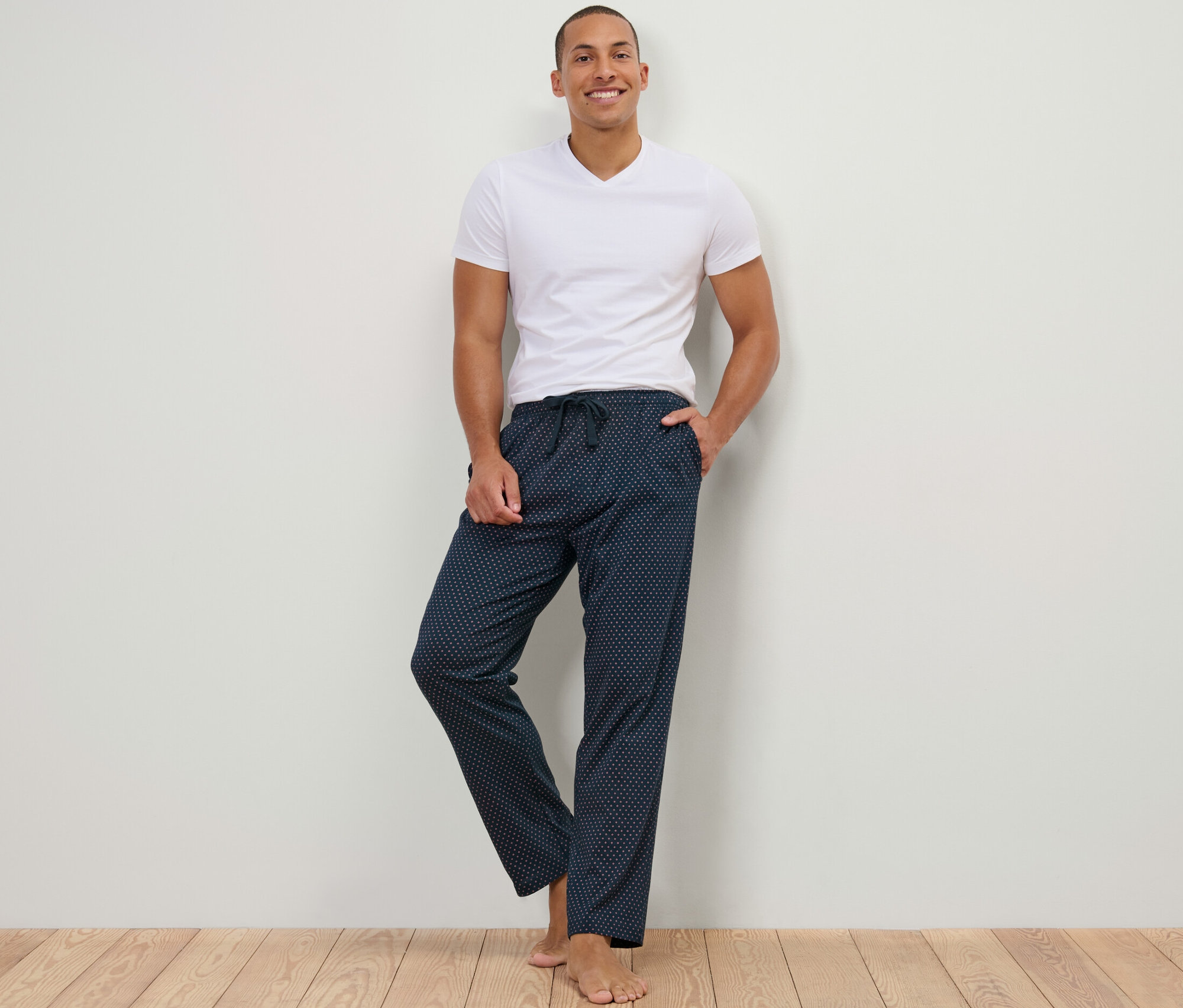 Un homme debout, portant un pantalon relax et un t-shirt.