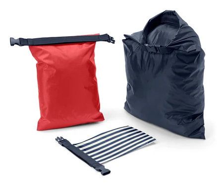 Un sac étanche rouge, un bleu et un bleu et blanc rayé enroulé sur un fond blanc.