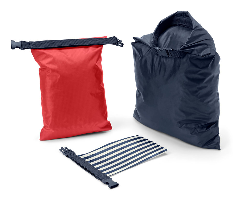 Un sac étanche rouge, un bleu et un bleu et blanc rayé enroulé sur un fond blanc.
