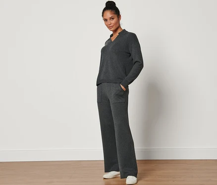 Femme posant en pantalon en maille.