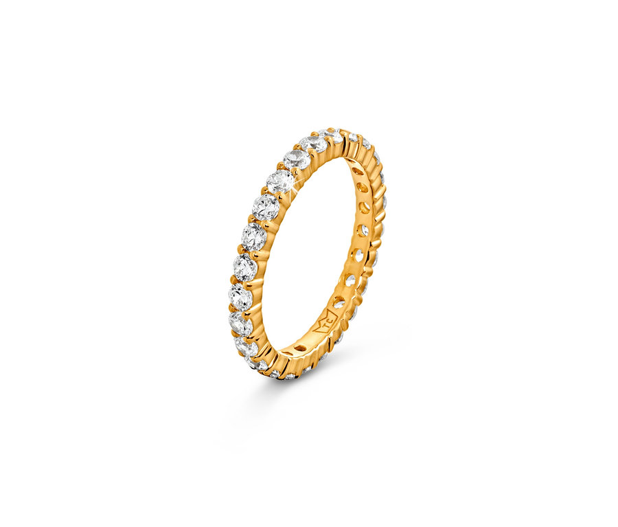 Gros plan d'une bague dorée avec des pierres transparentes. Anneau argent 925 mémoire, doré