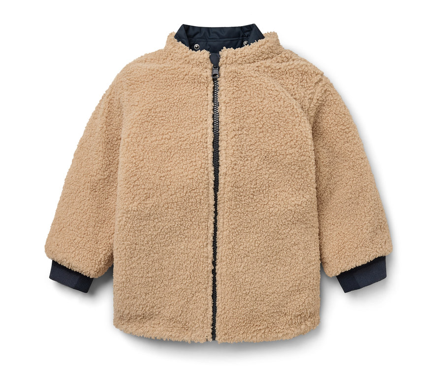 Veste en teddy beige avec fermeture éclair au centre.