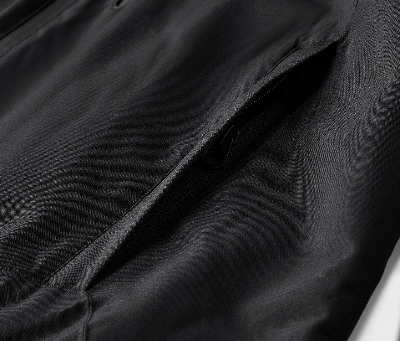 Détail d'une veste noire avec une poche.