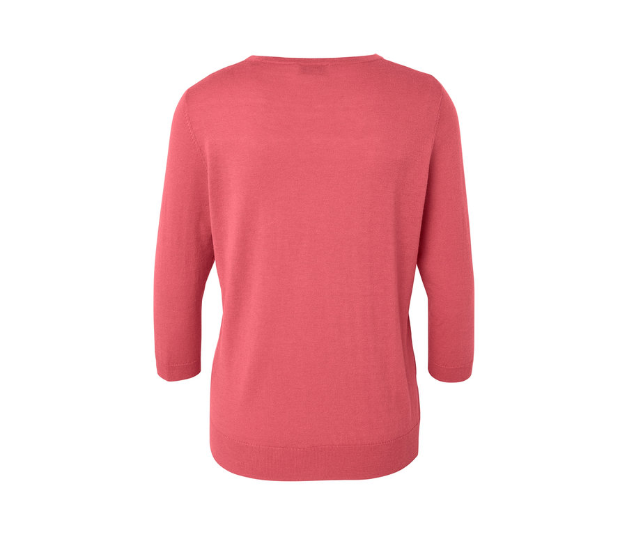 Gros plan sur un pull-over corail en maille fine avec soie.