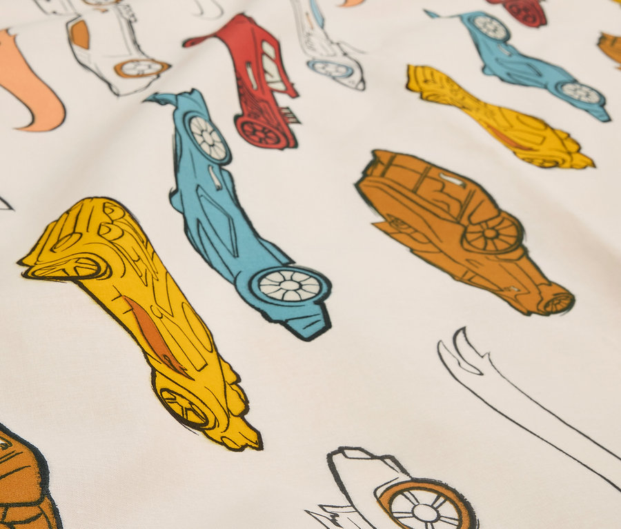 Gros plan sur un tissu imprimé avec des voitures de course stylisées de différentes couleurs.