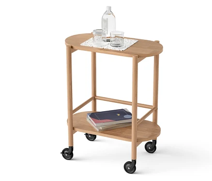 Chariot de bar en bois massif à 2 niveaux, avec une bouteille d'eau et des verres sur l'étagère supérieure, des livres en dessous.