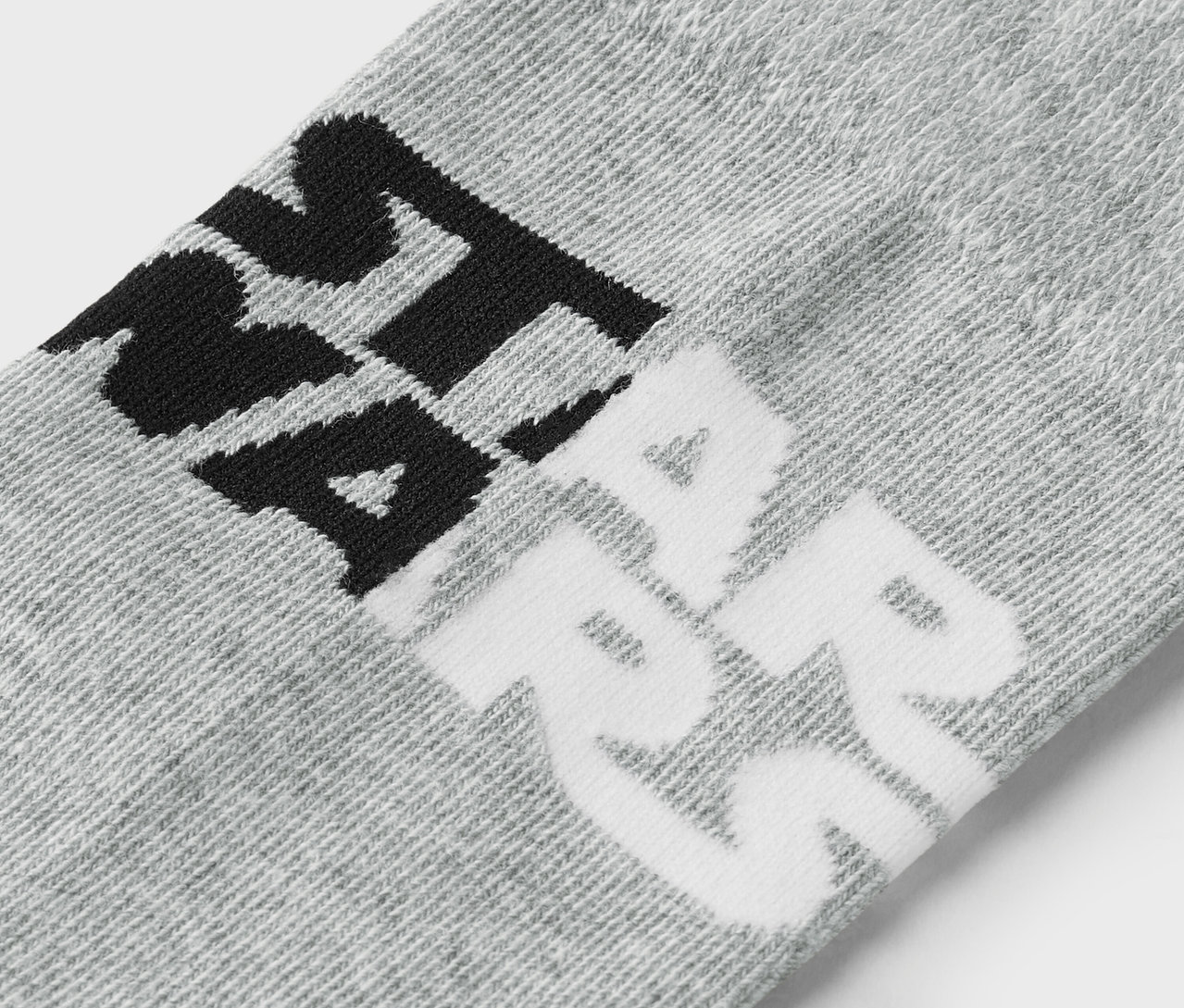 Gros plan d'une chaussette grise avec une inscription noire et blanche.