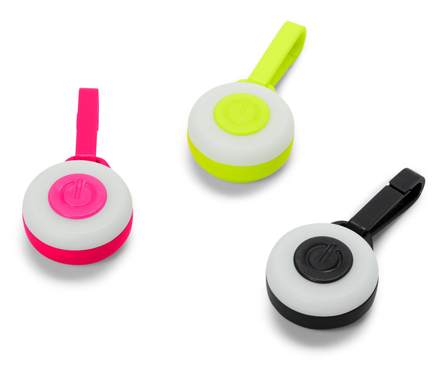 Trois lumières rondes avec des clips en rose, vert et noir.