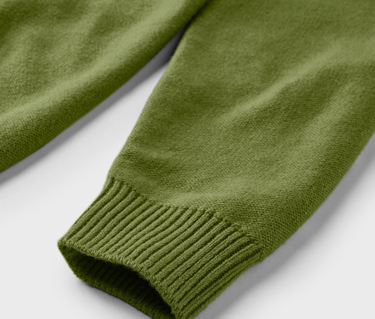 Gros plan sur un pull troyer tricoté vert.