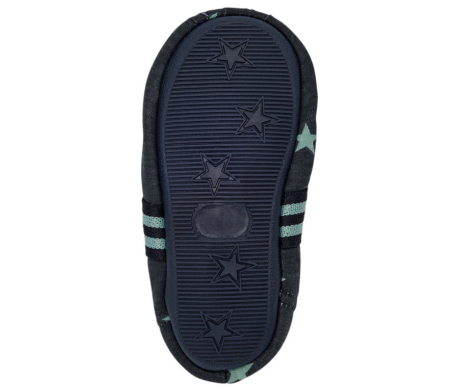 Semelle d'un chausson bleu en tissu pour bébé avec un motif d'étoiles.
