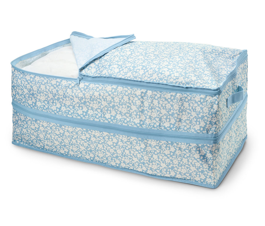 Boîte de rangement zippée avec motif floral bleu, partiellement ouverte, révélant un tissu blanc à l'intérieur.
