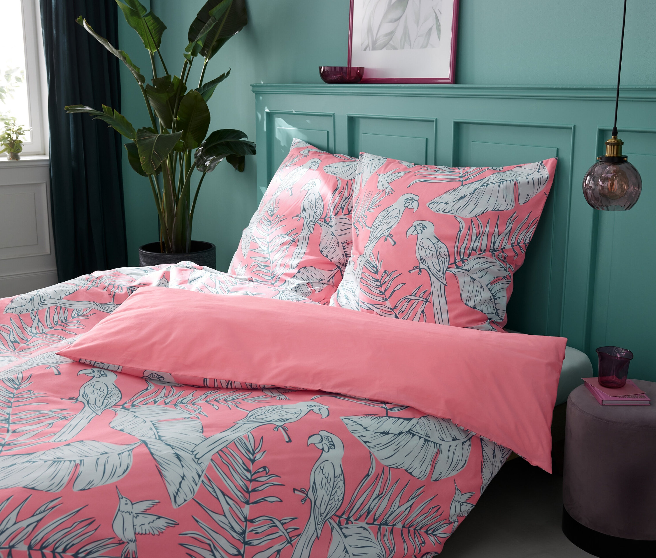 Quatre parures de lit en renforcé rose tropical de différentes tailles sur un lit.