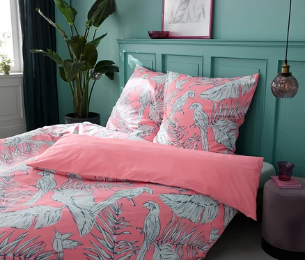 Quatre parures de lit en renforcé rose tropical de différentes tailles sur un lit.