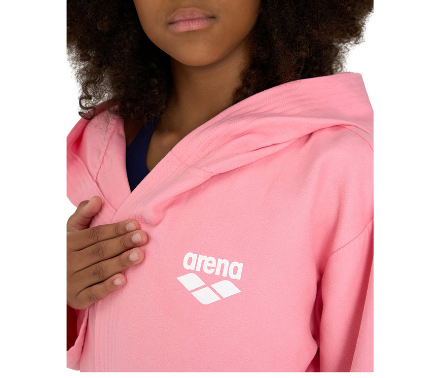 Enfant portant un peignoir pour enfant arena Zeal Plus JR rose à capuche, le logo arena blanc est visible sur la poitrine.