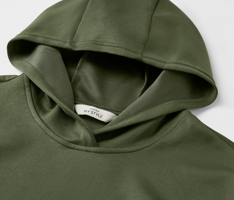 Gros plan sur un sweat à capuche vert foncé en mélange modal.