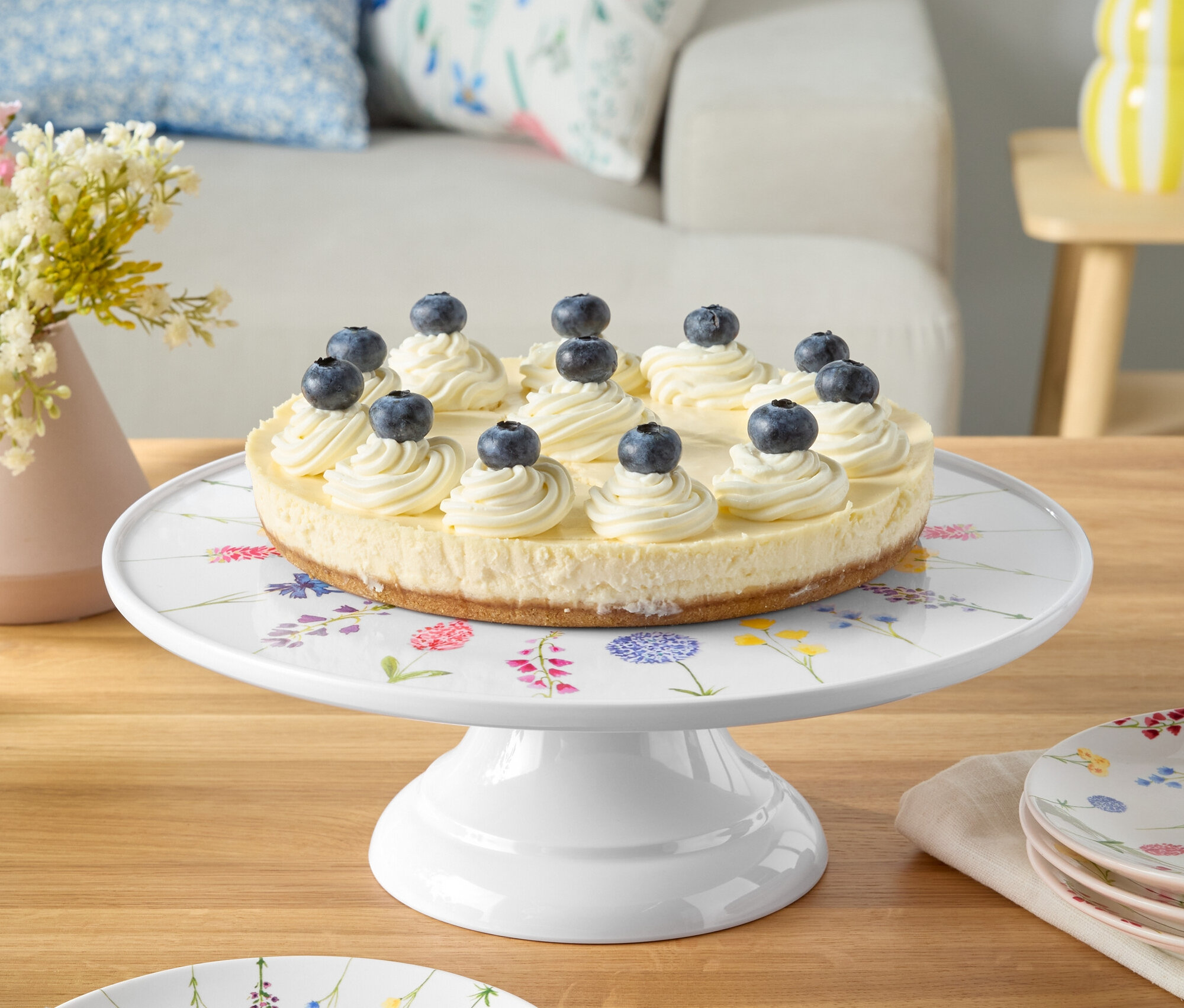Gâteau aux myrtilles sur un plat blanc à motifs floraux.