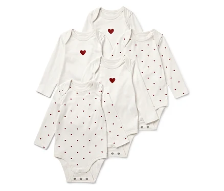 Cinq bodies blancs à manches longues pour bébé, certains avec un cœur rouge au centre, d'autres avec un motif de cœurs rouges.