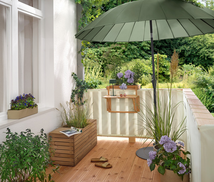 Sur un balcon, un parasol vert Leco Shanghai (Ø 270 cm) est posé sur un pied plat Leco (Ø env. 60 cm).