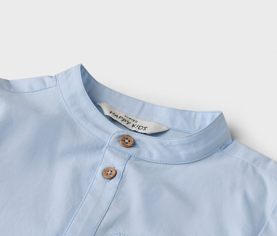 Gros plan sur une chemise bleu clair avec deux boutons et un col.