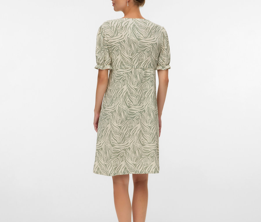 Femme vue de dos portant une robe à motif zébré jusqu'aux genoux et des sandales.