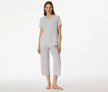 Femme portant un pyjama 3/4 SCHIESSER avec un t-shirt rayé gris et blanc et un pantalon 3/4 gris sur fond blanc.