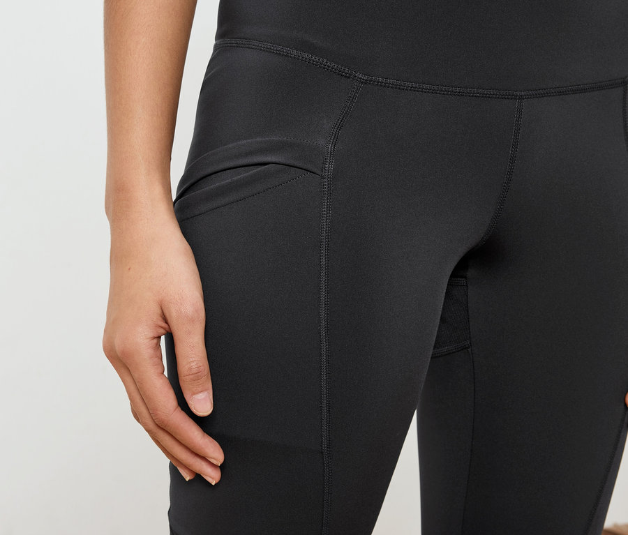 Gros plan d'une femme portant des leggings noirs avec une poche.