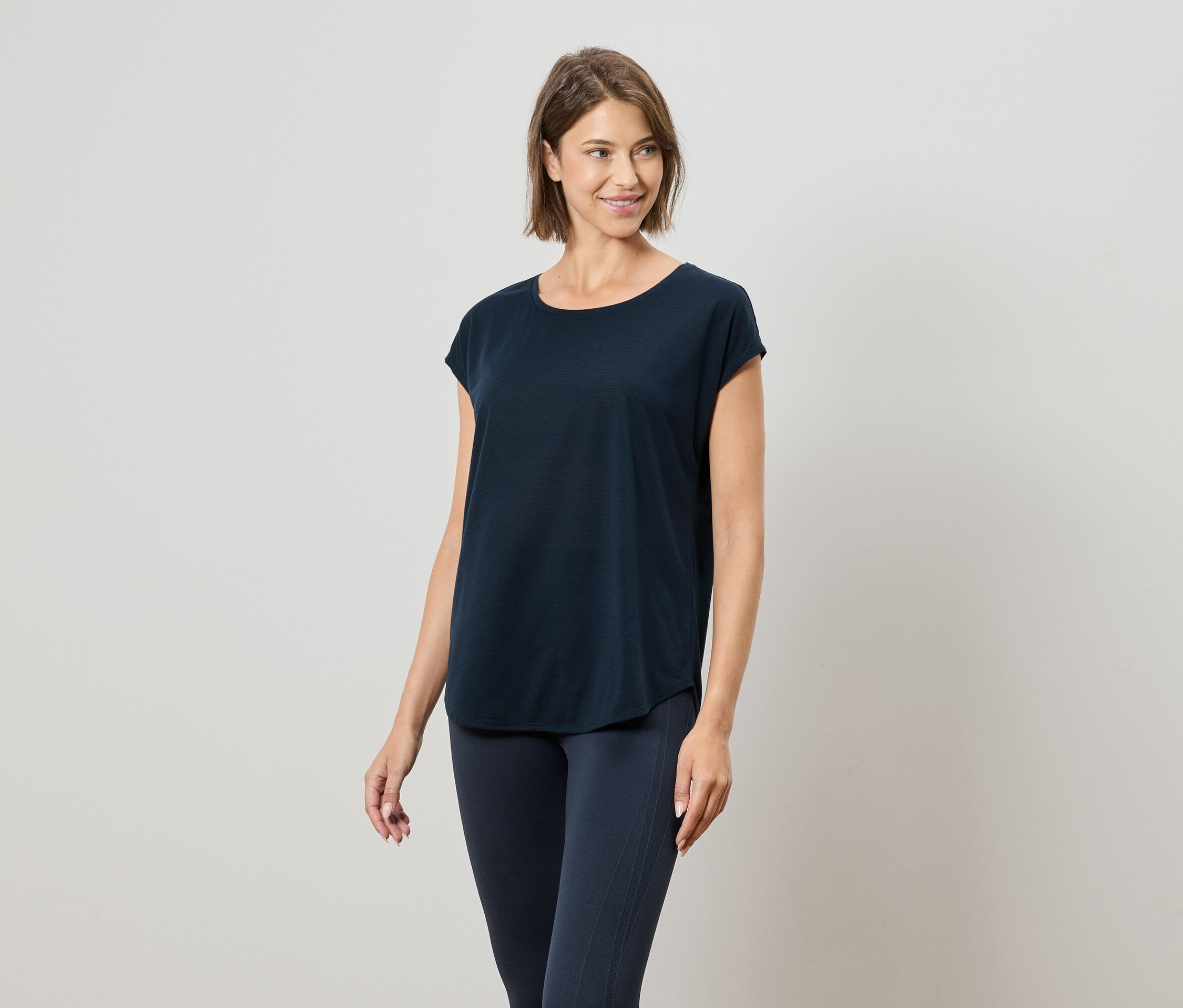 Femme portant un t-shirt bleu marine et un legging bleu marine.