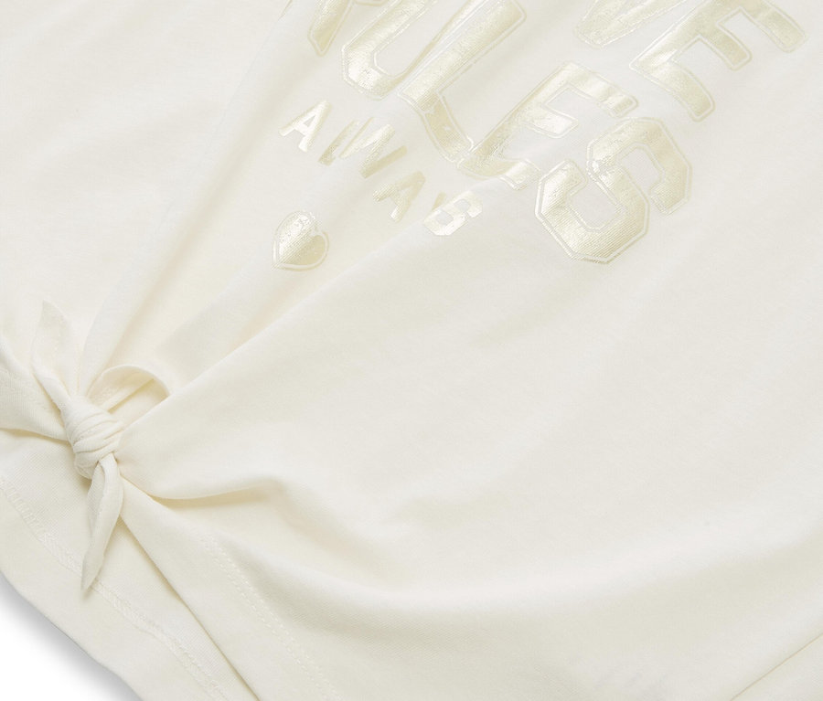 Gros plan sur un t-shirt blanc avec l'inscription "Love Rules Always" et un nœud sur l'ourlet.
