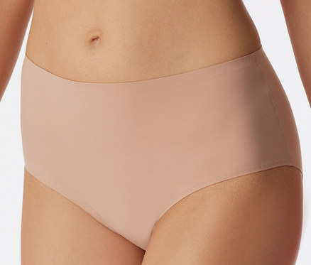 Une personne porte un slip maxi invisible SCHIESSER couleur érable.