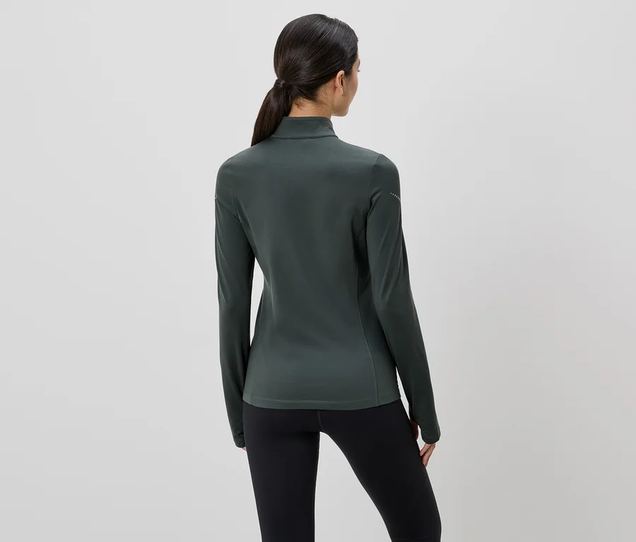 Vue arrière d'une femme portant un haut à manches longues vert foncé et un legging noir, les cheveux attachés en queue de cheval.