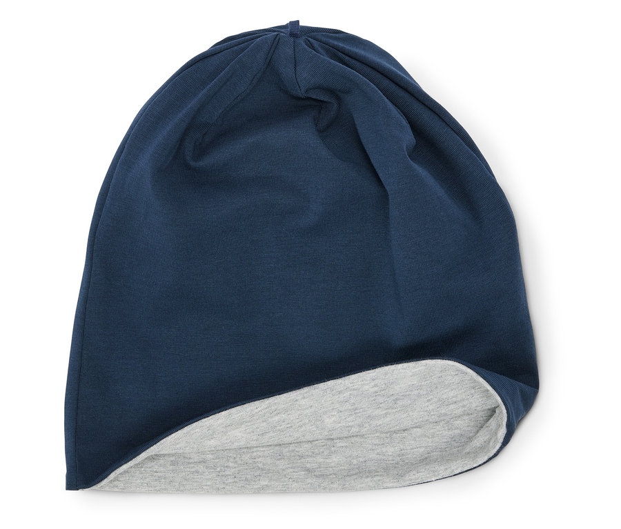 Un bonnet bleu marine avec une doublure gris clair posé sur un fond blanc.