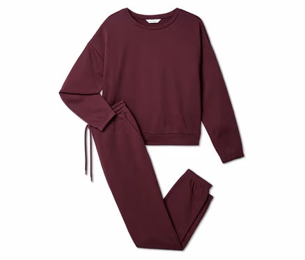 Ensemble de survêtement bordeaux composé d'un sweat-shirt et d'un pantalon de jogging posé sur un fond blanc.