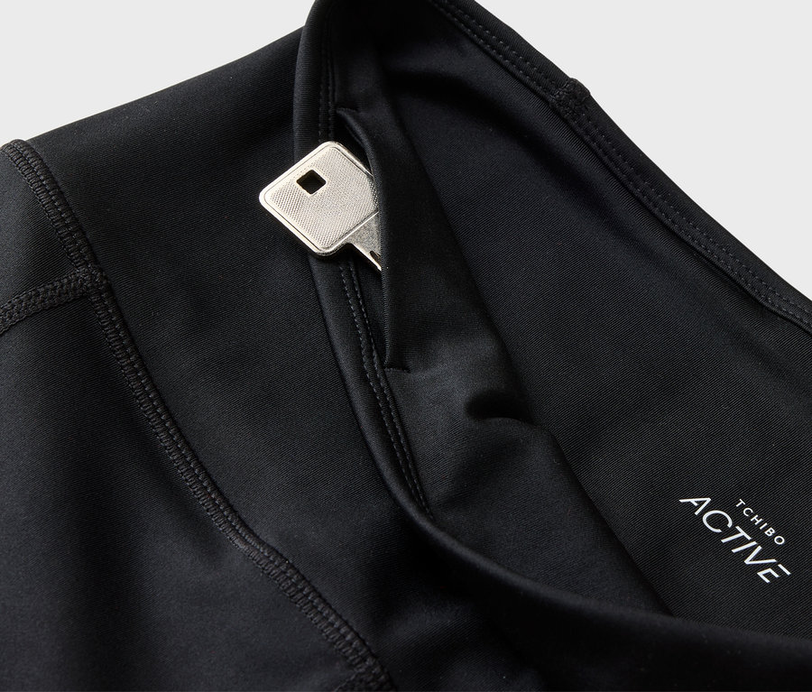 Gros plan sur un legging noir avec une clé argentée dans la poche.
