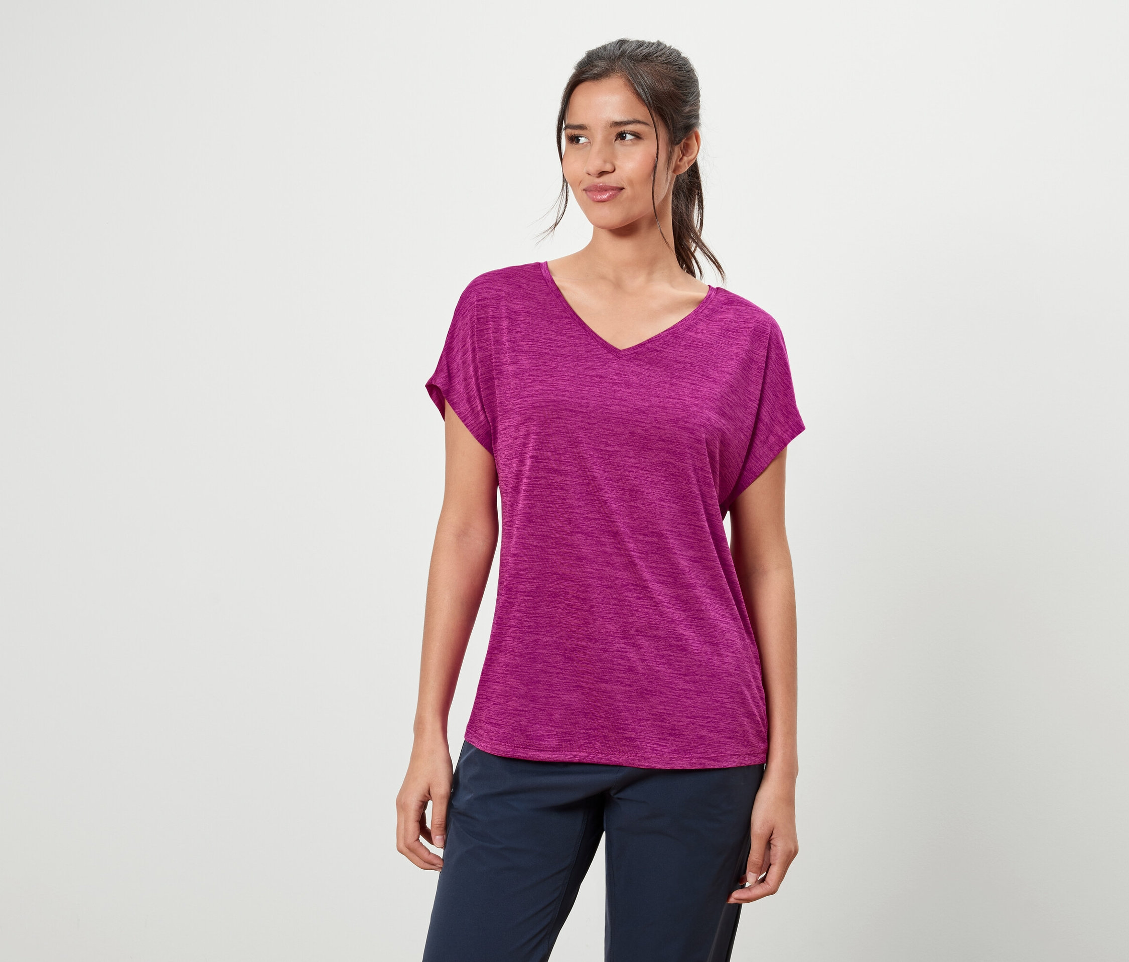 Femme portant un t-shirt violet et un pantalon bleu.