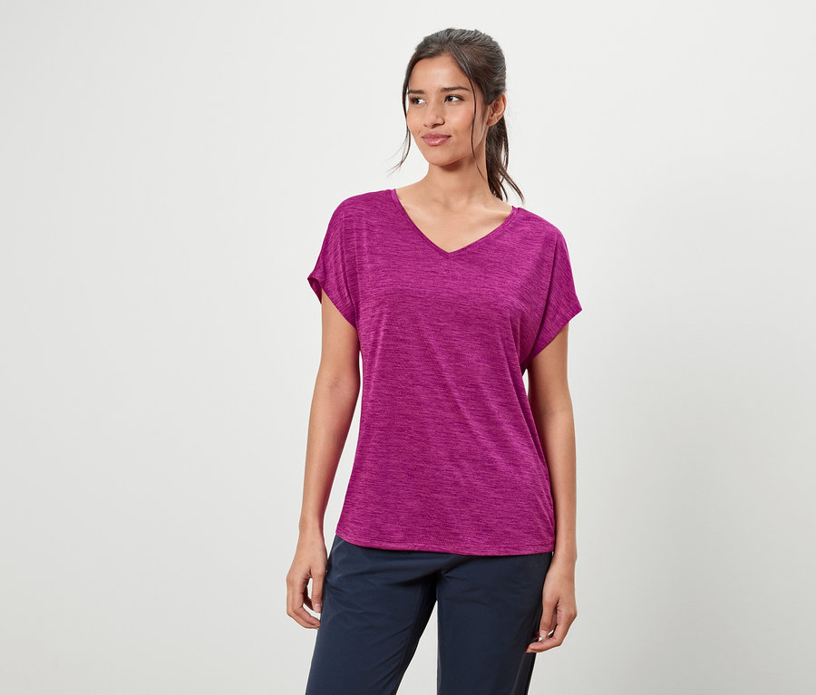 Femme portant un t-shirt violet et un pantalon bleu.