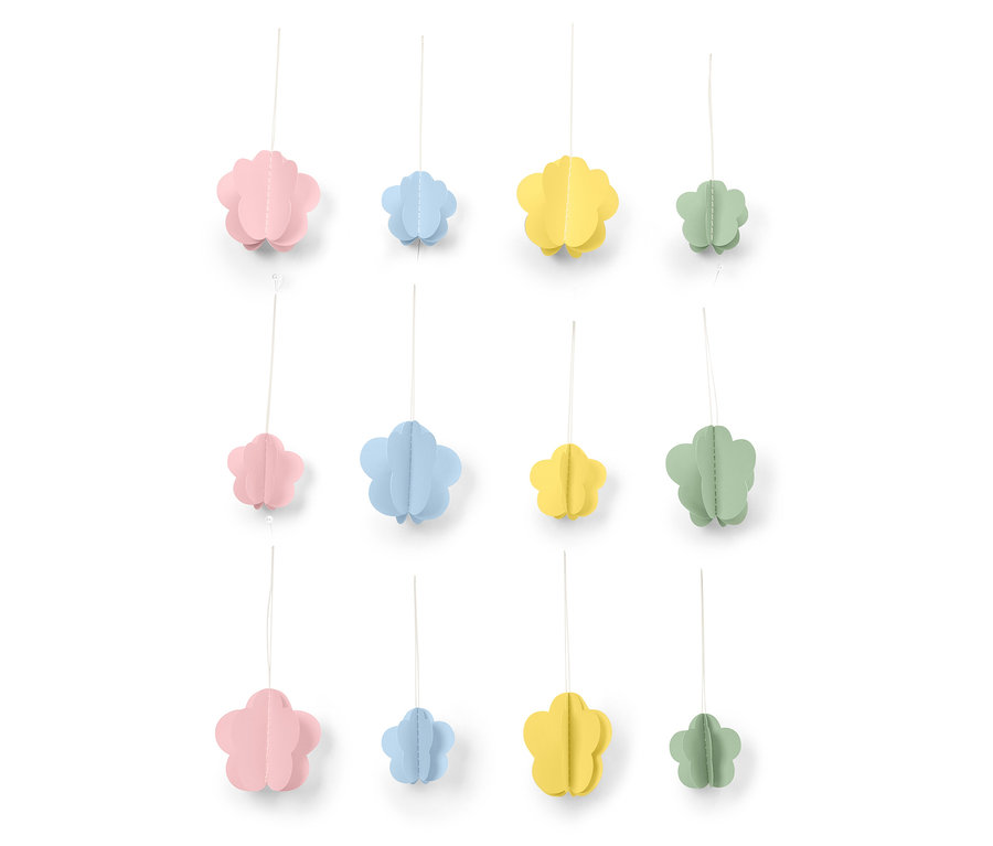 Des fleurs décoratives en papier rose, bleu, jaune et vert sont suspendues à des fils devant un fond blanc.