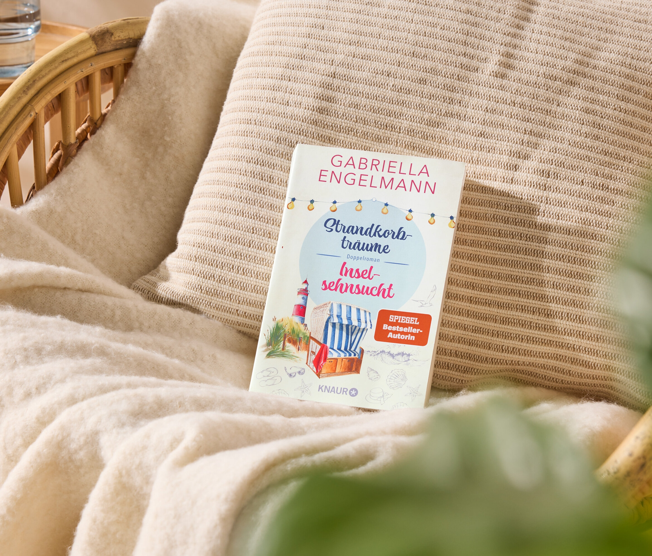 Sur un fauteuil se trouve un livre intitulé « Strandkorbtäume Inselsehnsucht » de Gabriella Engelmann.