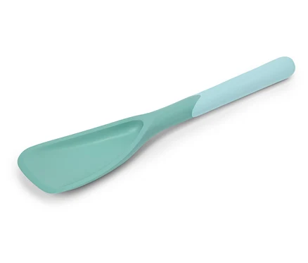 Une spatule turquoise avec un manche bleu clair est posée en diagonale sur un fond blanc.