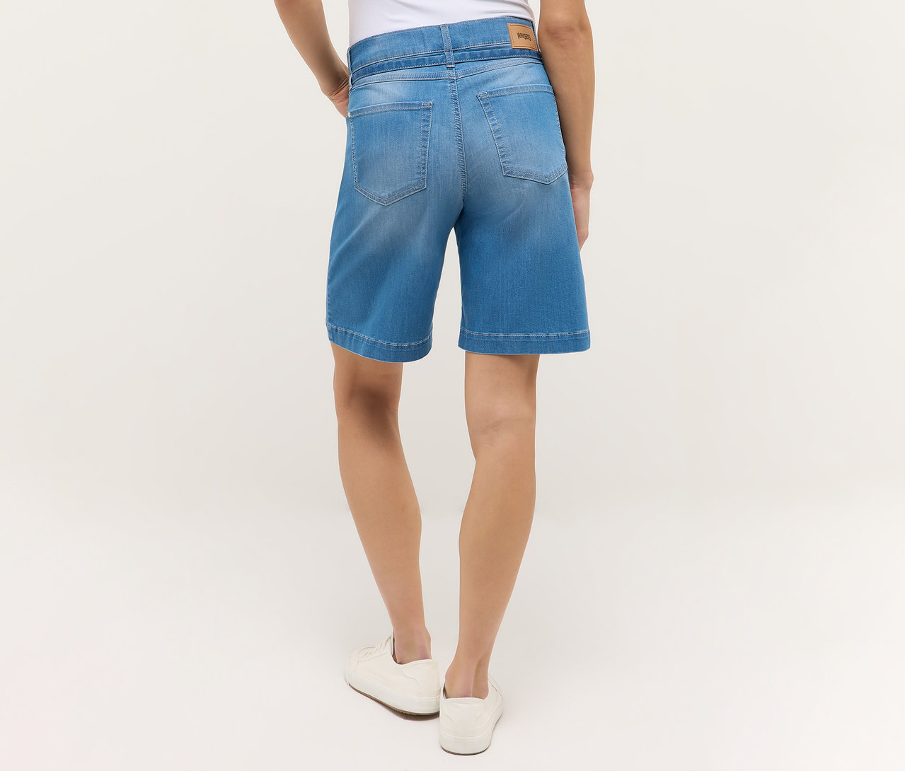 Vue arrière d'une femme portant un short Angels Denim «
Lia City
» bleu clair et des chaussures blanches.